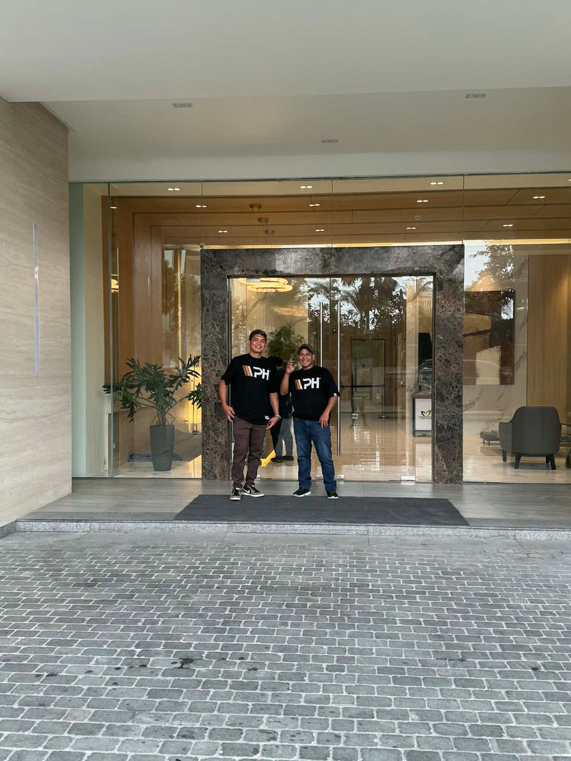 Wood Panel Philippines Contractor standing in front of a modern building entrance.