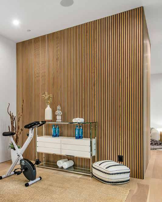 Modern interior with Natural Oak  Felt Acoustic Wood Wall Panel, exercise bike, and decorative items.