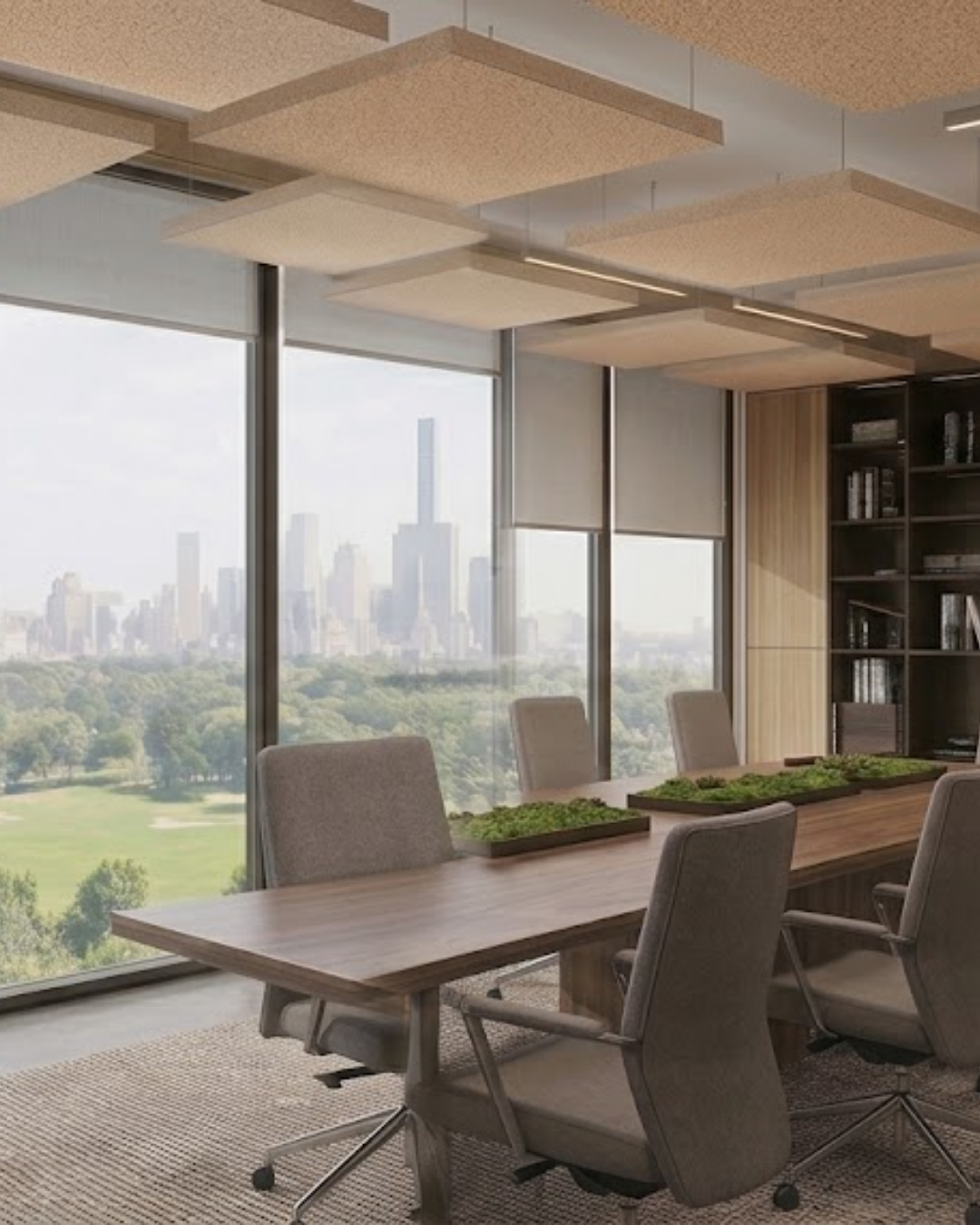Modern conference room with a long wooden table, gray upholstered chairs, suspended Acoustic Baffle ceiling panels, and large windows overlooking a city skyline and green park.