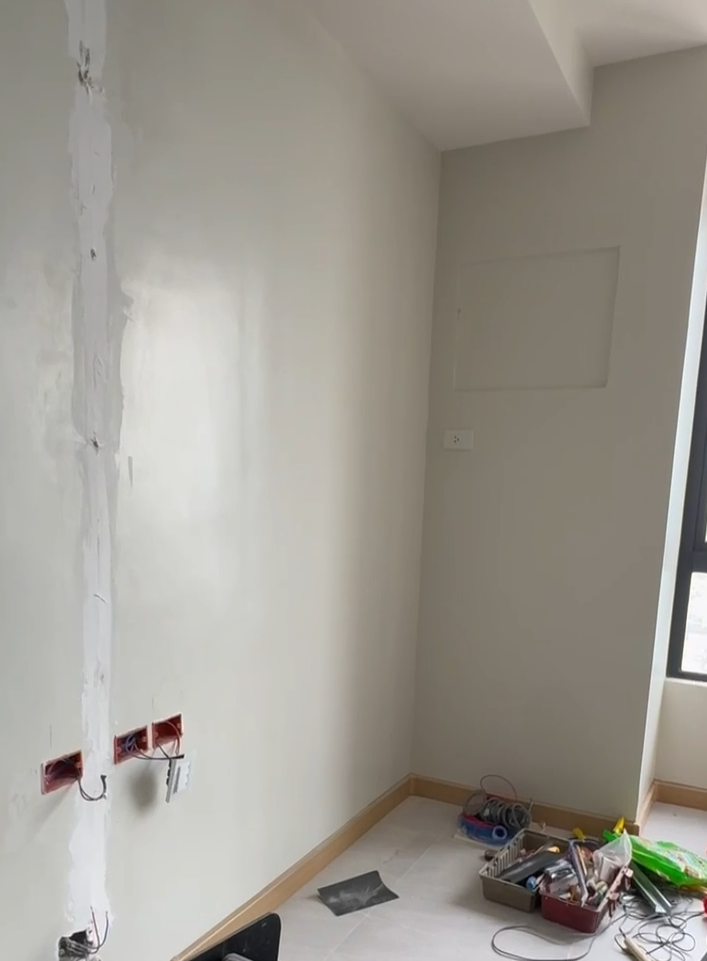 Unfinished room with exposed wires and tools on the floor