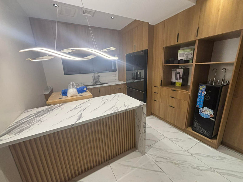 Modern kitchen with marble island, wooden cabinets, and stainless steel appliances By Wood Panel Philippines.