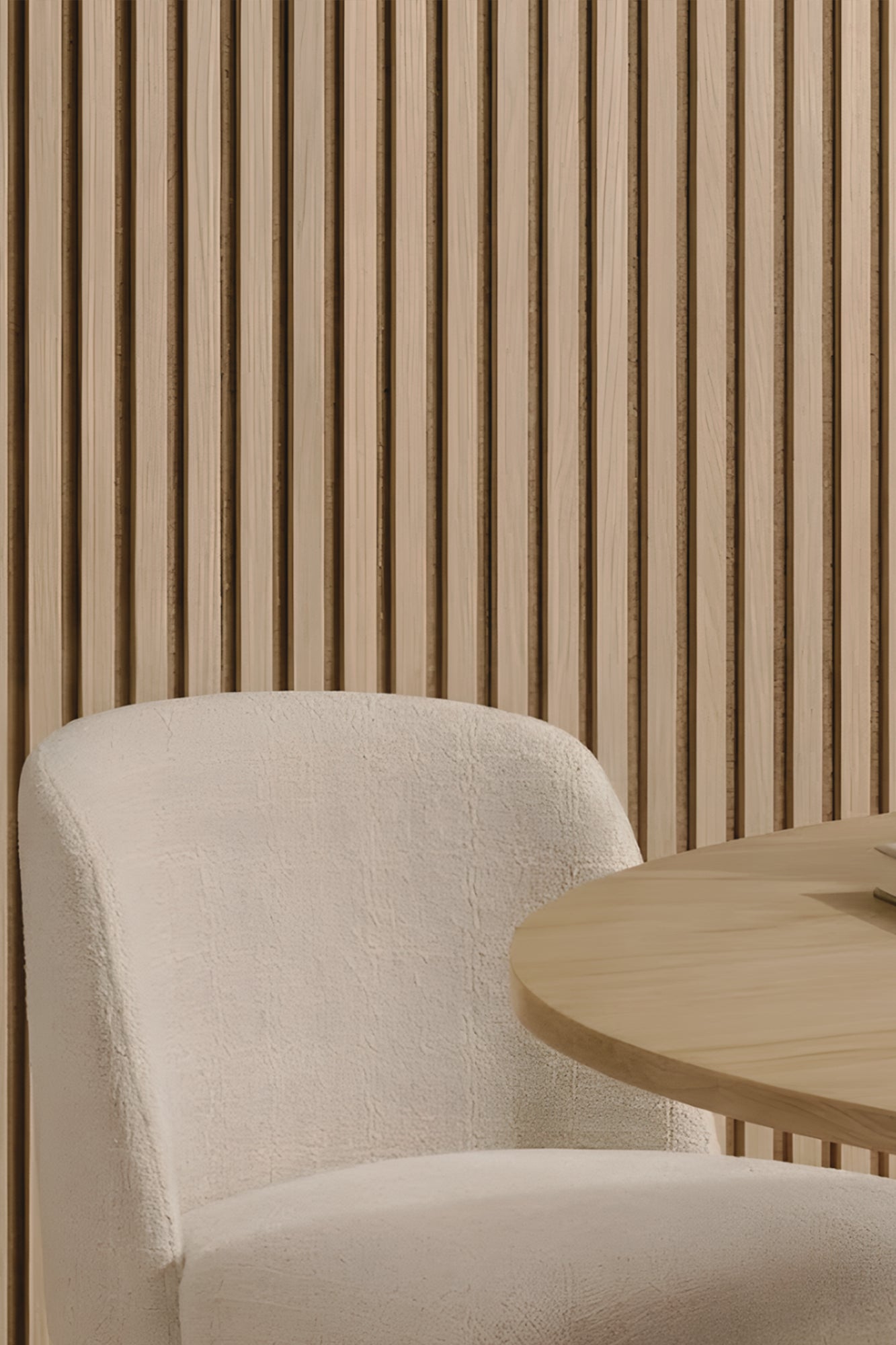 Beige chair and wooden table against a slatted Oak Beige Acoustic Wood Wall Panel