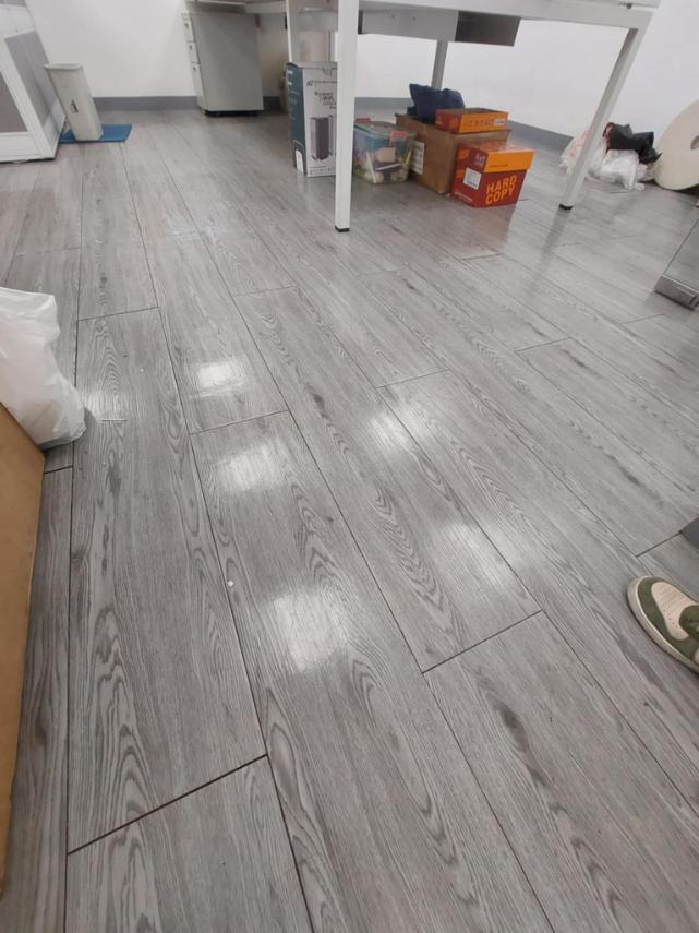 Gray Vinyl Flooring by Wood Panel Philippines floor tiles in a room with furniture and boxes.