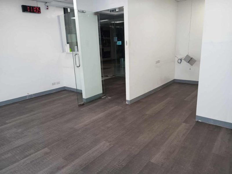 Empty office room with Vinyl Flooring by Wood Panel Philippine and a glass door.