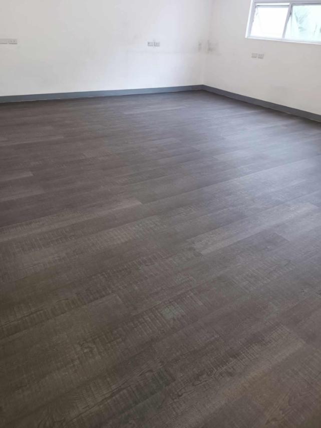Empty room with Vinyl Flooring by Wood Panel Philippines and white walls.