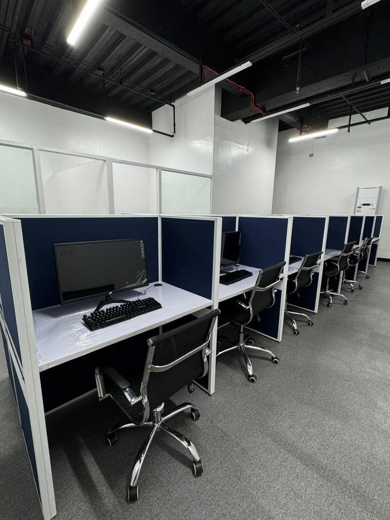 Row of office desks with computer setups in a modern office space By Wood Panel Philippines