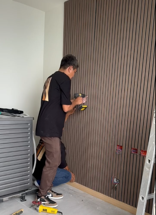 Wood Panel Philippines Contractor installing Acoustic Wall Panels in a room with tools and a ladder.